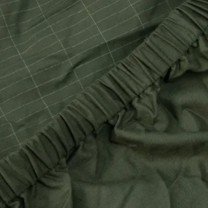 Od blizu vidimo visokokvalitetni kroj ozemljitvene rjuhe v naravni olivno zeleni barvi z kvadratnimi všitki srebrne niti, kar združuje stilsko lepoto in uporabnost rjuhe.